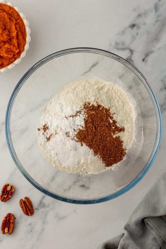 A glass bowl filled with flour, cinnamon, baking soda, and baking powder. 