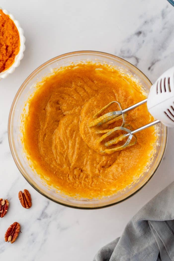 Mixing the pumpkin cake batter in a glass bowl.