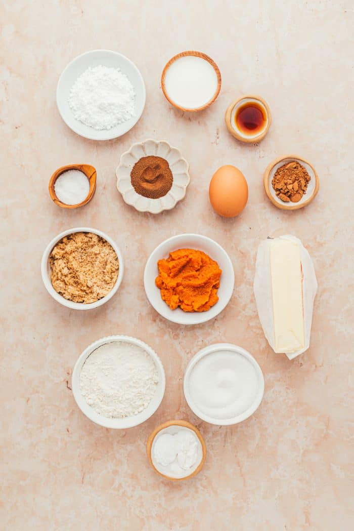 White bowls filled with ingredients for pumpkin spice latte cookies.