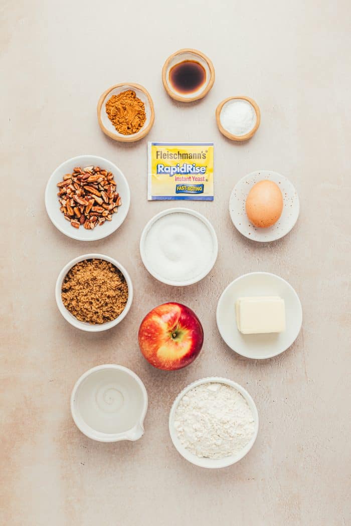 Various bowls with ingredients for making salted caramel apple cinnamon rolls. 