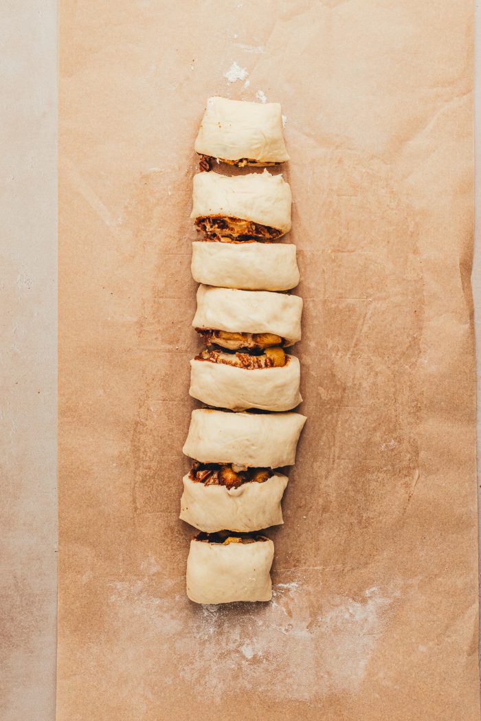 The cinnamon roll dough rolled up and sliced with the filling inside.