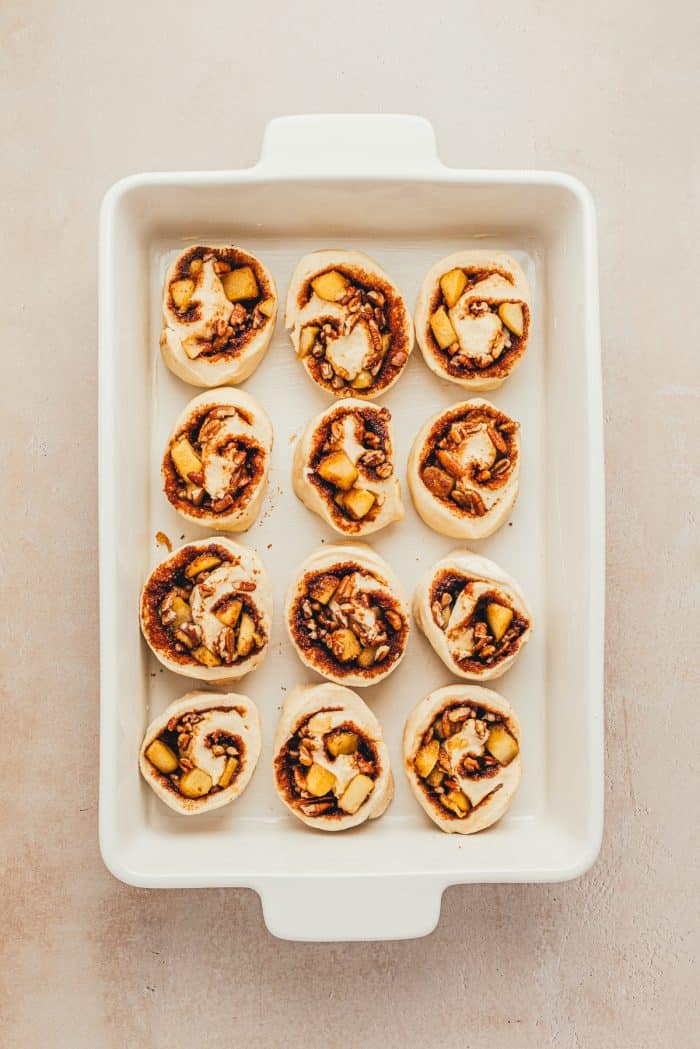 The cinnamon rolls placed in a white baking dish.