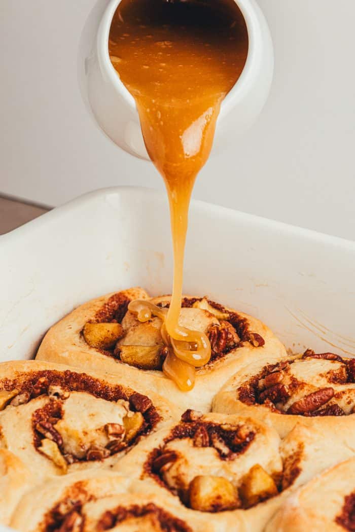 Caramel sauce drizzled over cinnamon rolls.