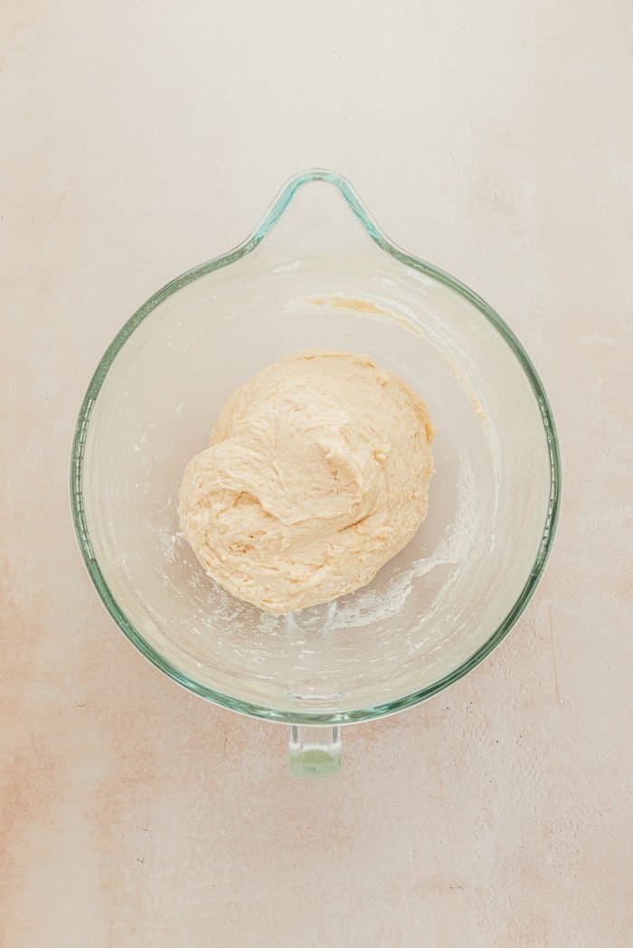 A glass bowl with the butter mixture and flour mixed together.