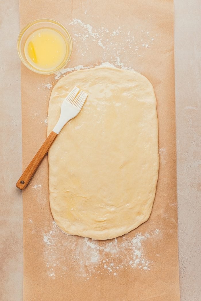 The rolled out dough is brushed with melted butter.