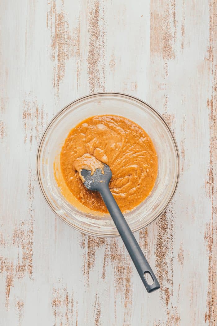 The batter for Apple Blondies in a glass bowl with a spatula.