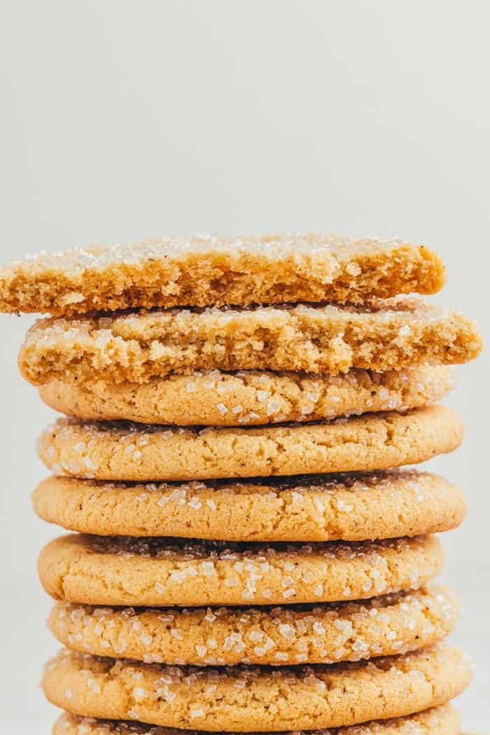 A stack of browned butter sugar cookies and two cookies have been broken in half. 