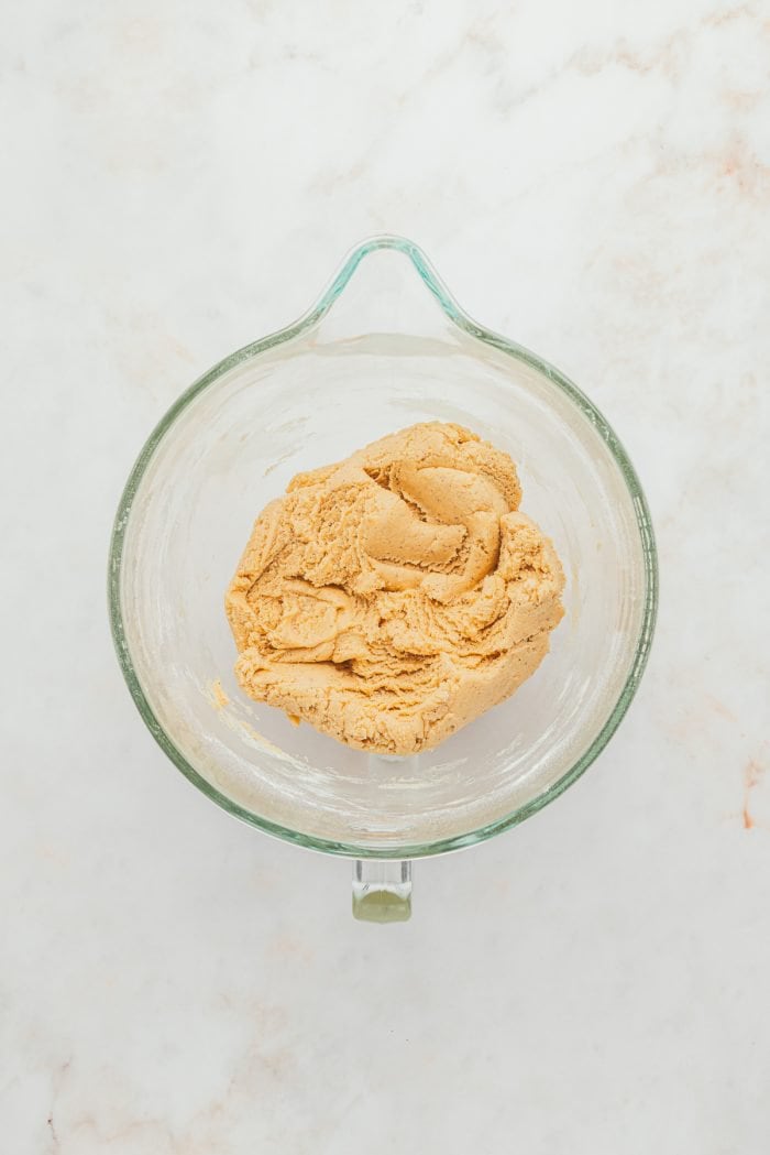 Raw browned butter sugar cookie dough in a glass bowl.