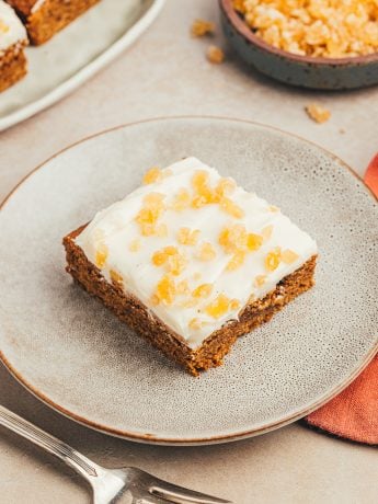 A gray plate with a gingerbread cookie bar on it.