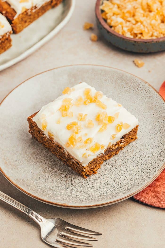 A gray plate with a gingerbread cookie bar on it.