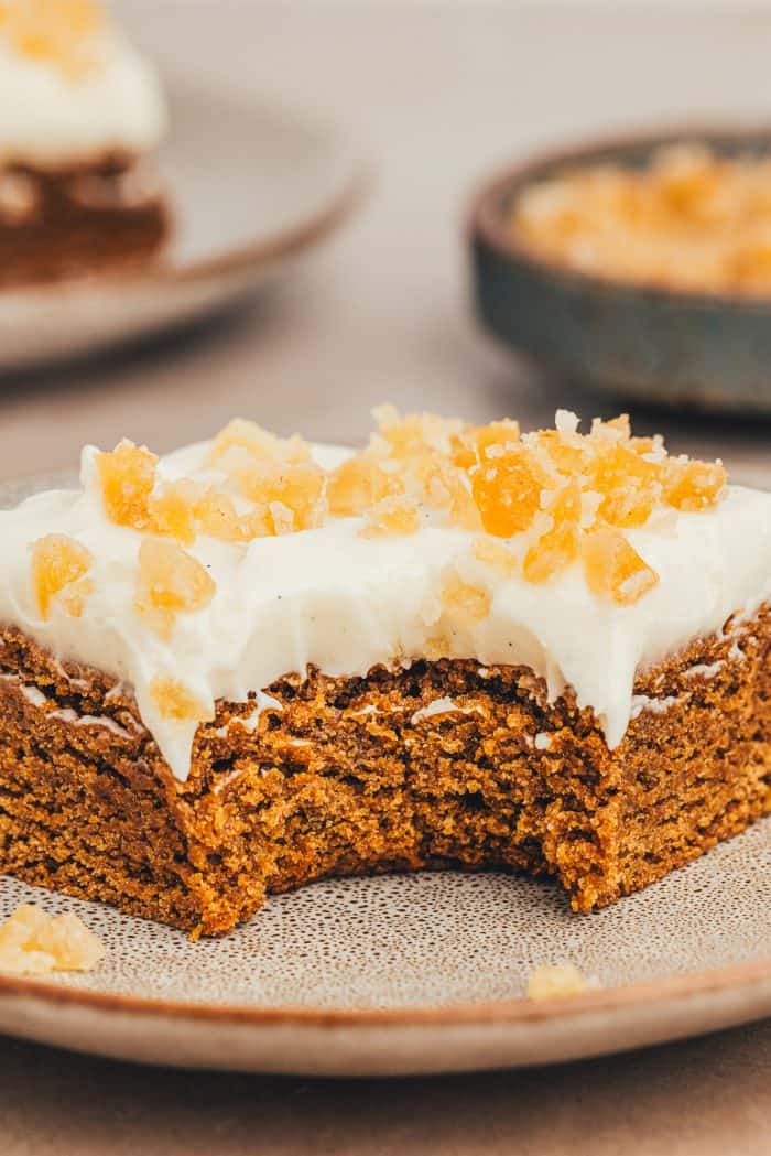 A frosted gingerbread bar with a bite taken out of it.