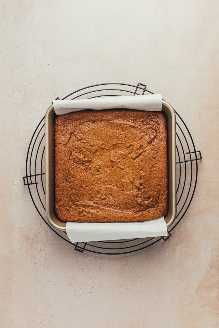 Baked gingerbread bars without the frosting. The baking pan is cooling on a cooling rake.