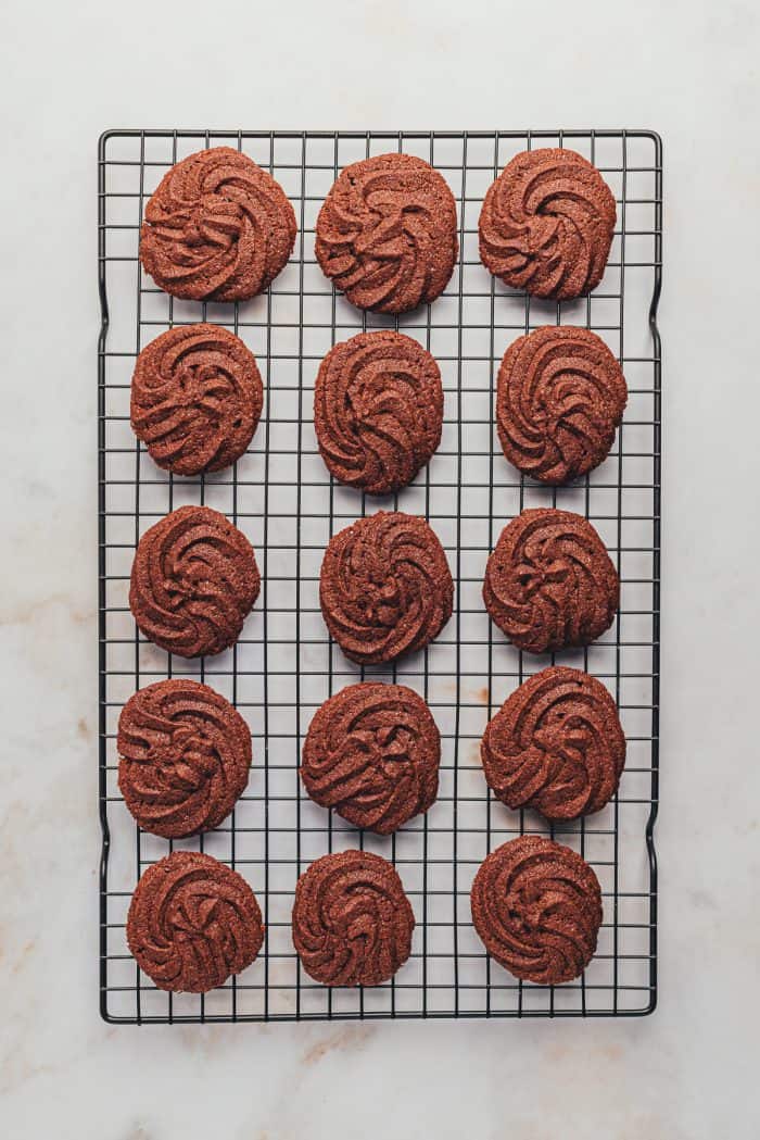 The baked orange chocolate cookies cooling on a cooling rack.