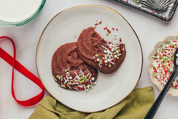 A plate with two chocolate dipped chocolate orange cookies.