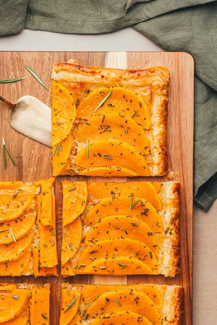 Slices of butternut squash on a wooden cutting board.