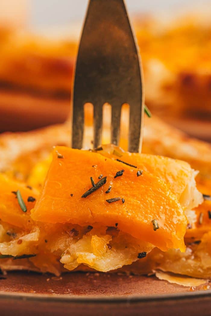 A fork piercing through a slice of butternut squash.