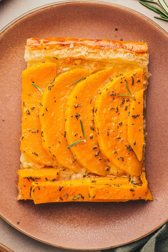 An image of a slice of butternut squash on a brown plate.