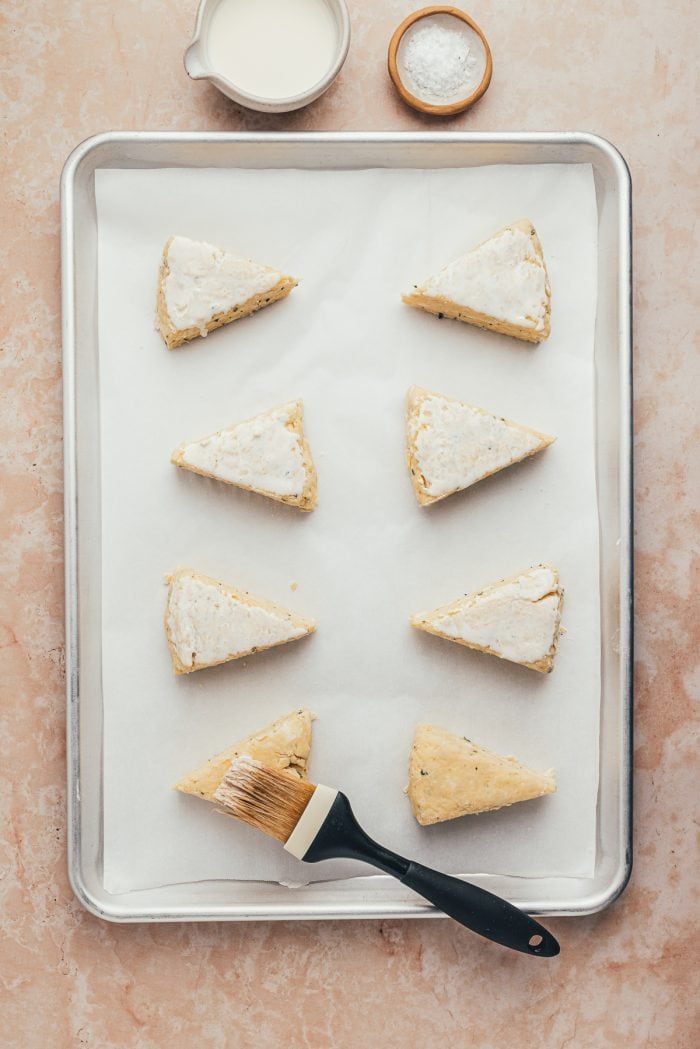 The unbaked scones on a parchment-lined baking sheet.