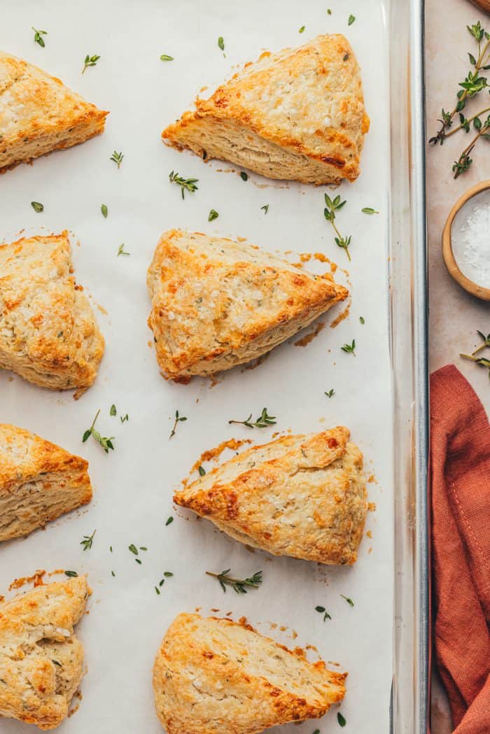 Baked thyme scones on a parchment-lined baking sheet.