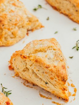 Baked thyme scones on a parchment-lined baking sheet.