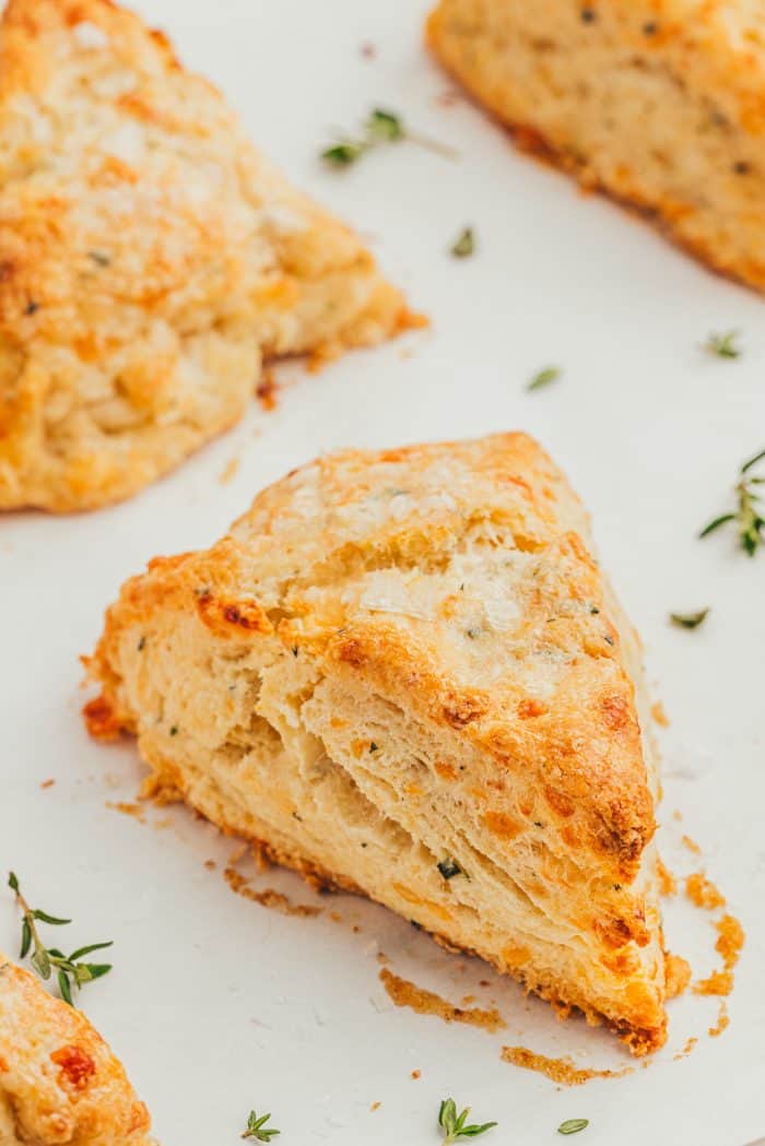 Baked thyme scones on a parchment-lined baking sheet.