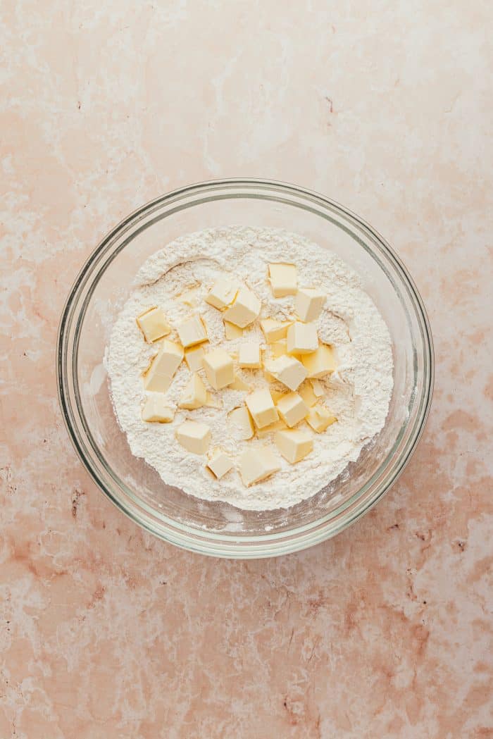 A glass bowl with cubed butter and flour.