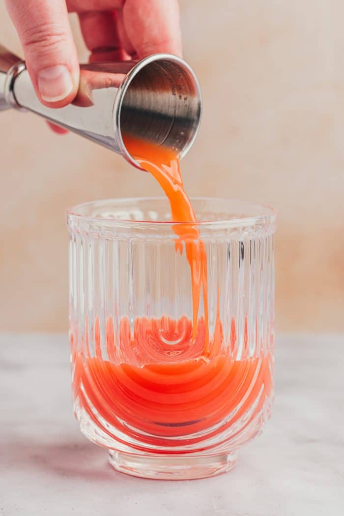 Blood orange juice being poured into a glass.