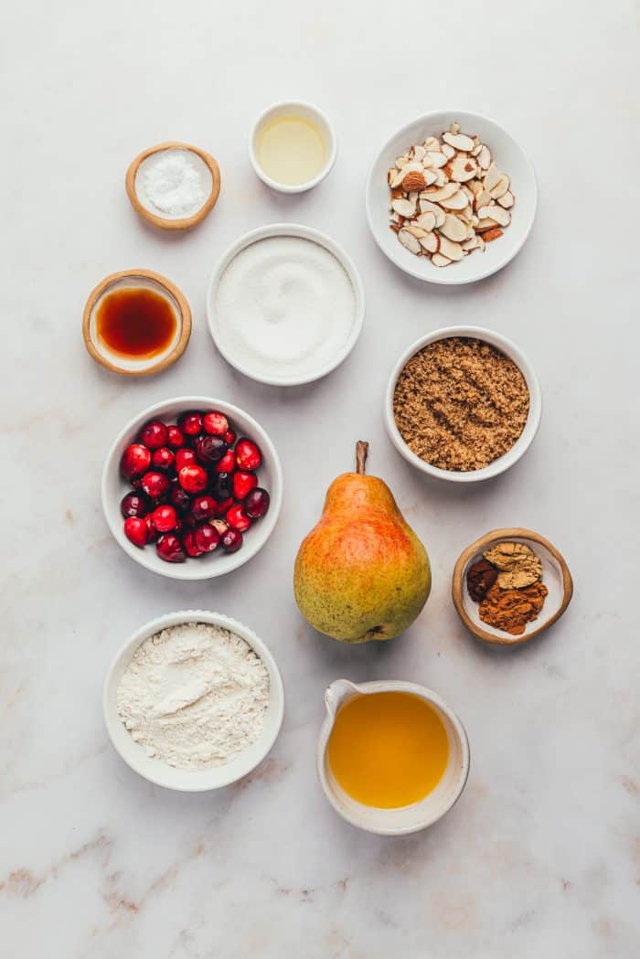 Various bowls with the ingredients for cranberry pear crumble.