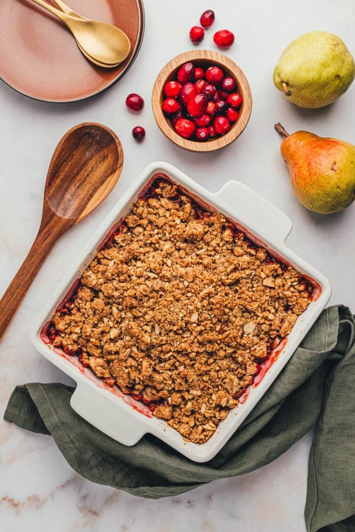 An overhead view of a square white baking dish with cranberry pear crumble.