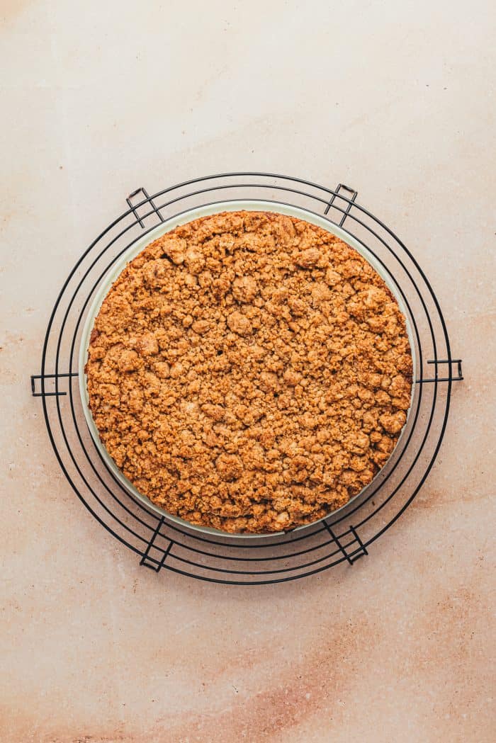 A baked coffee cake with the cake pan removed on a cooling rack.