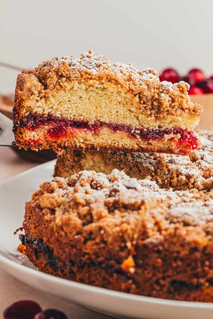 A slice of coffee cake being removed from the whole cake.