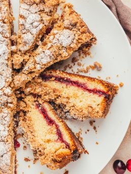 A large plate with slices of coffee cake showing the jam center.