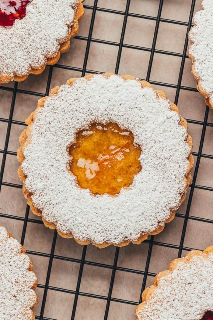 An upclose image of a Linzer cookie with a jam center and powdered sugar.