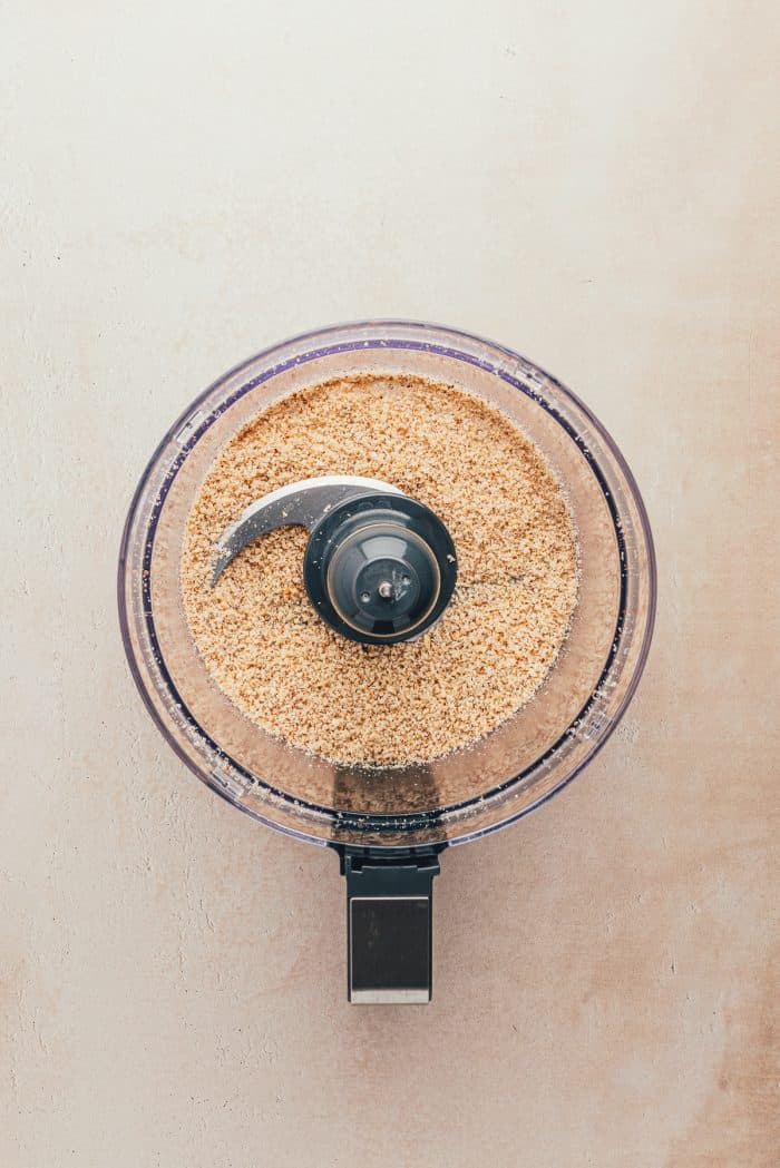 A food processor with Hazelnuts that have been ground.