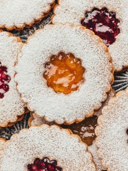 Upclose of Linzer cookies showing the jam center and powdered sugar.