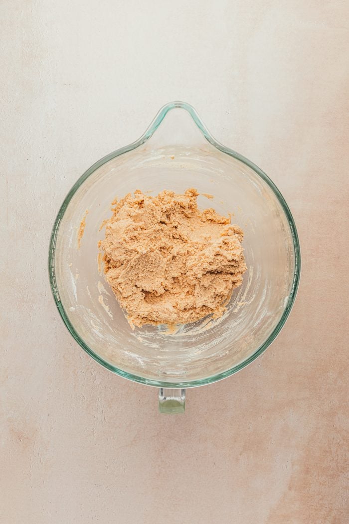 A glass measuring cup with cookie batter.