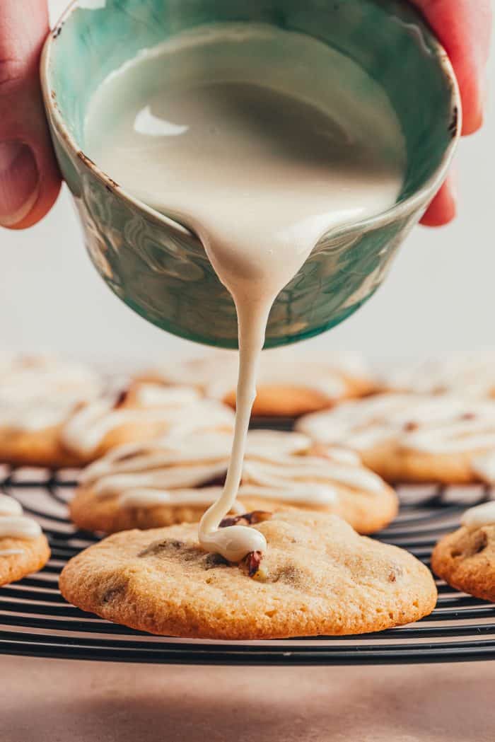 Glaze being poured over drop cookies.