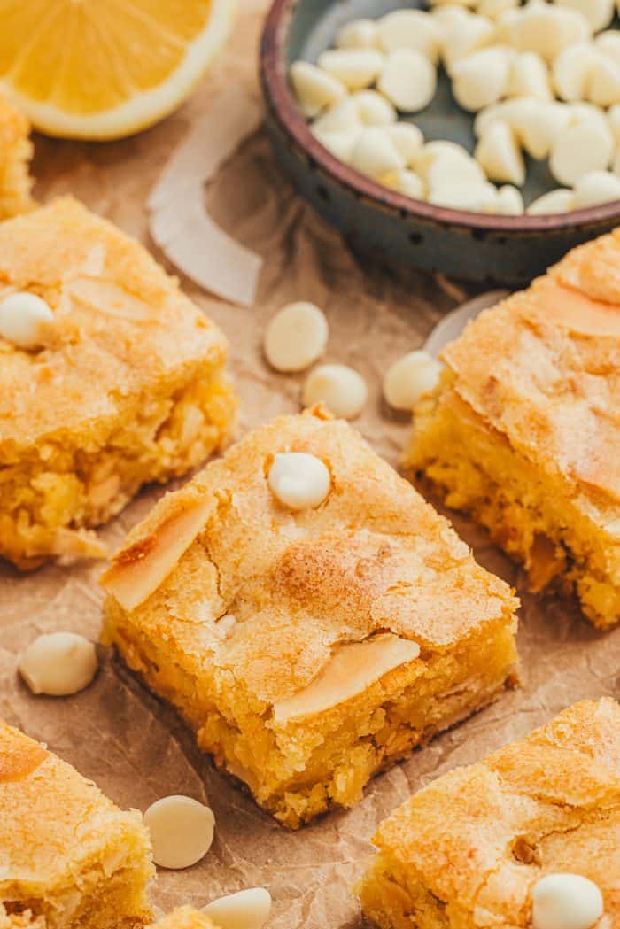 Lemon blondies cut into bars with white chocolate chips sprinkled around.