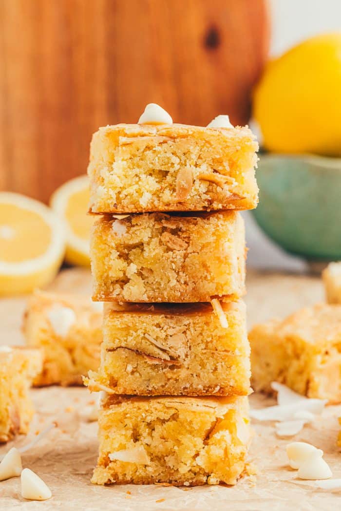 A stack of lemon blondies with half cut lemons in the background.