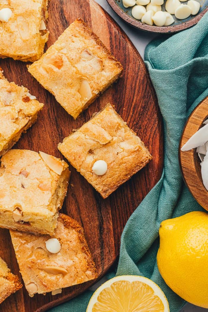 Lemon blondies cut into bars with white chocolate chips sprinkled around.