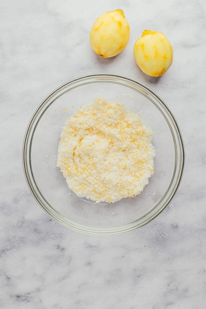 Sugar with lemon zest in a glass bowl.