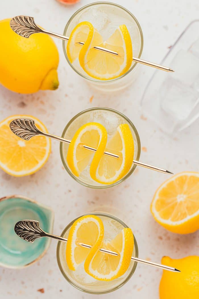 An image of three tall glasses with lemon elderflower mocktail and garnished with lemon slices.