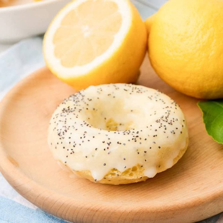 A lemon poppyseed donut on a wooden tray.