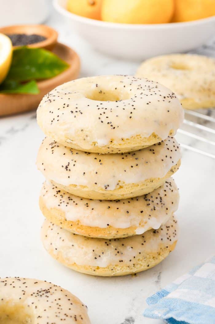 Various lemon donuts stacked on a white surface.