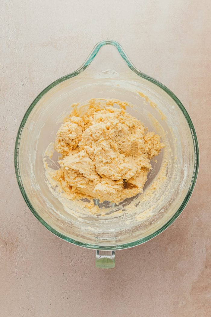 A glass bowl with lemon sugar cookie dough.