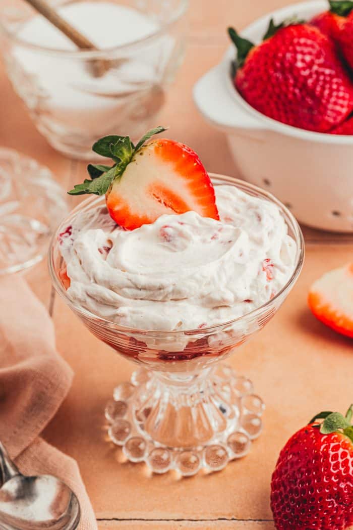 A glass parfait dish with homemade strawberry fool.