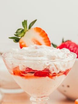 A glass parfait dish with strawberry mascarpone fool.