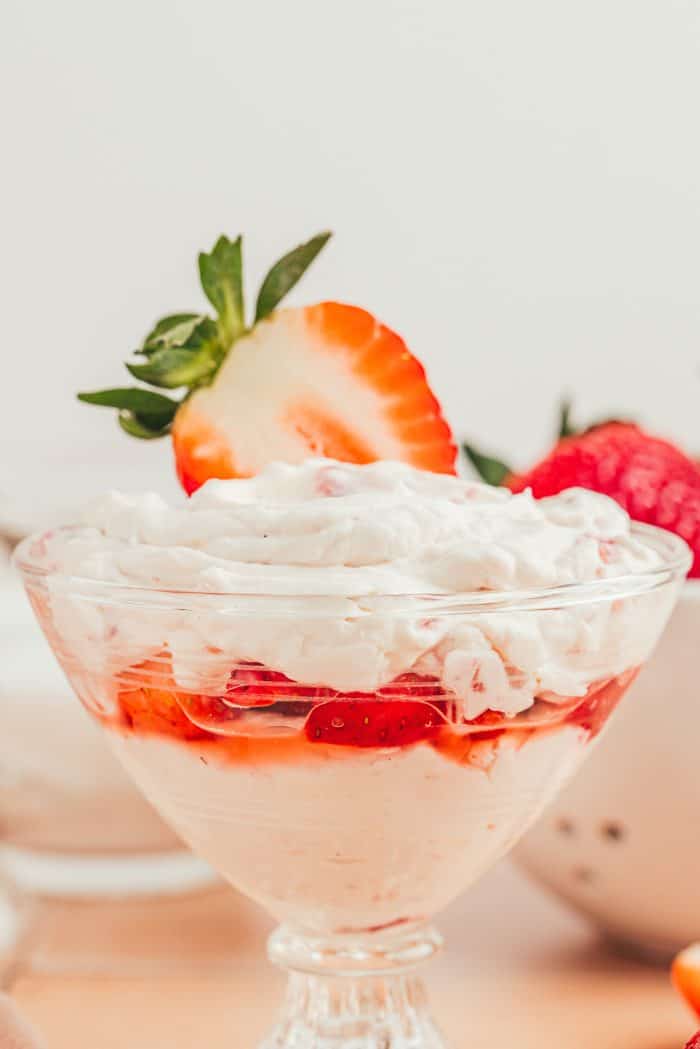 A glass parfait dish with strawberry mascarpone fool.