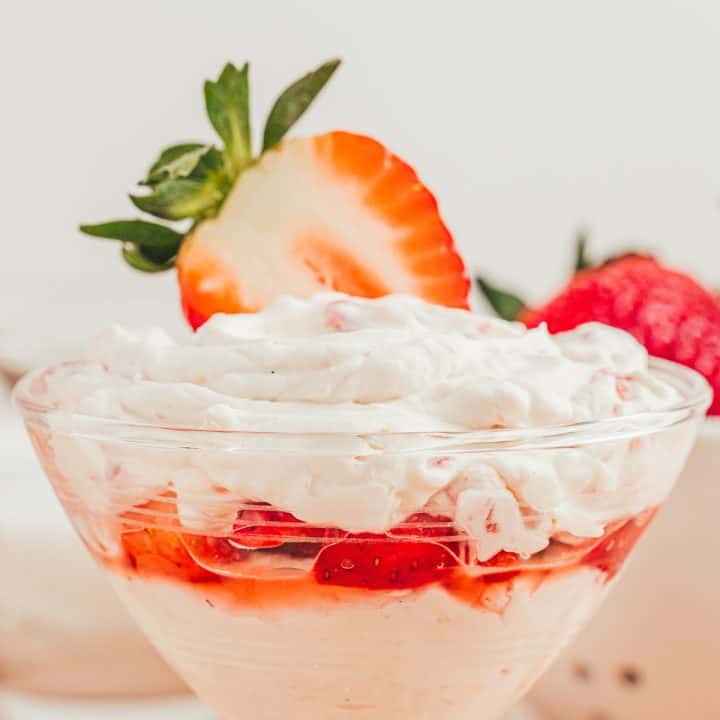 A glass parfait dish with strawberry mascarpone fool.