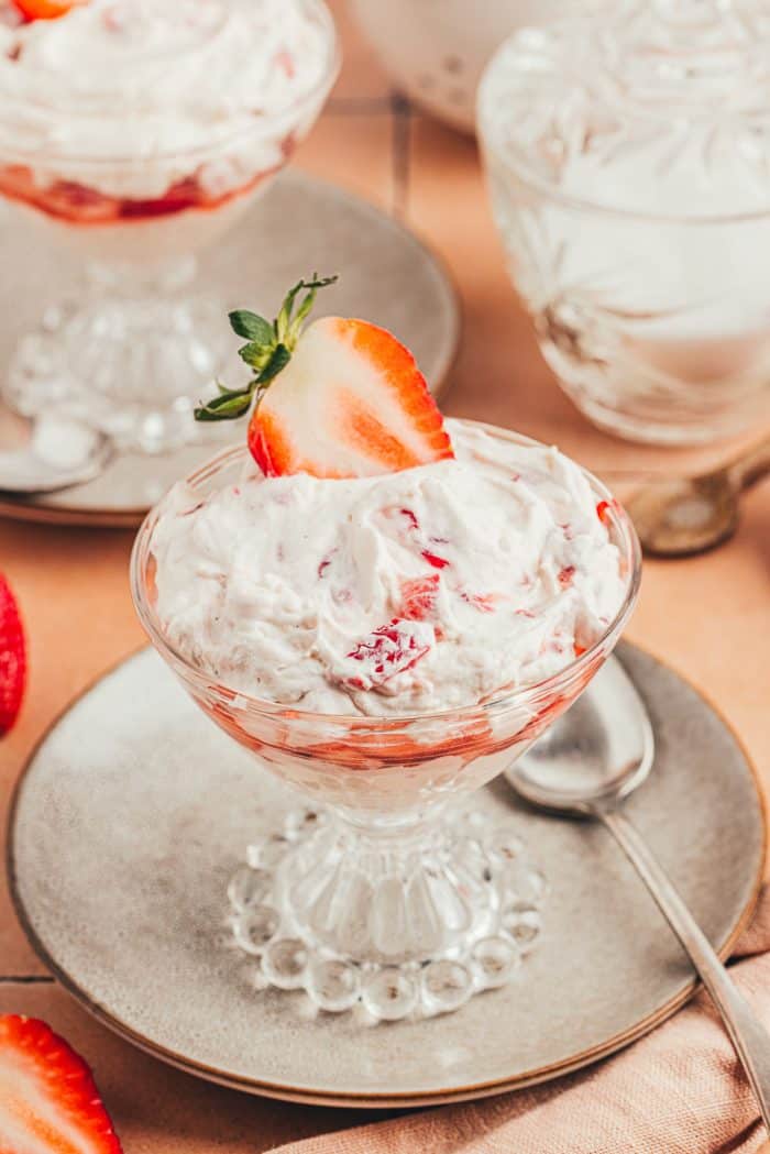 A glass parfait dish with homemade strawberry fool.